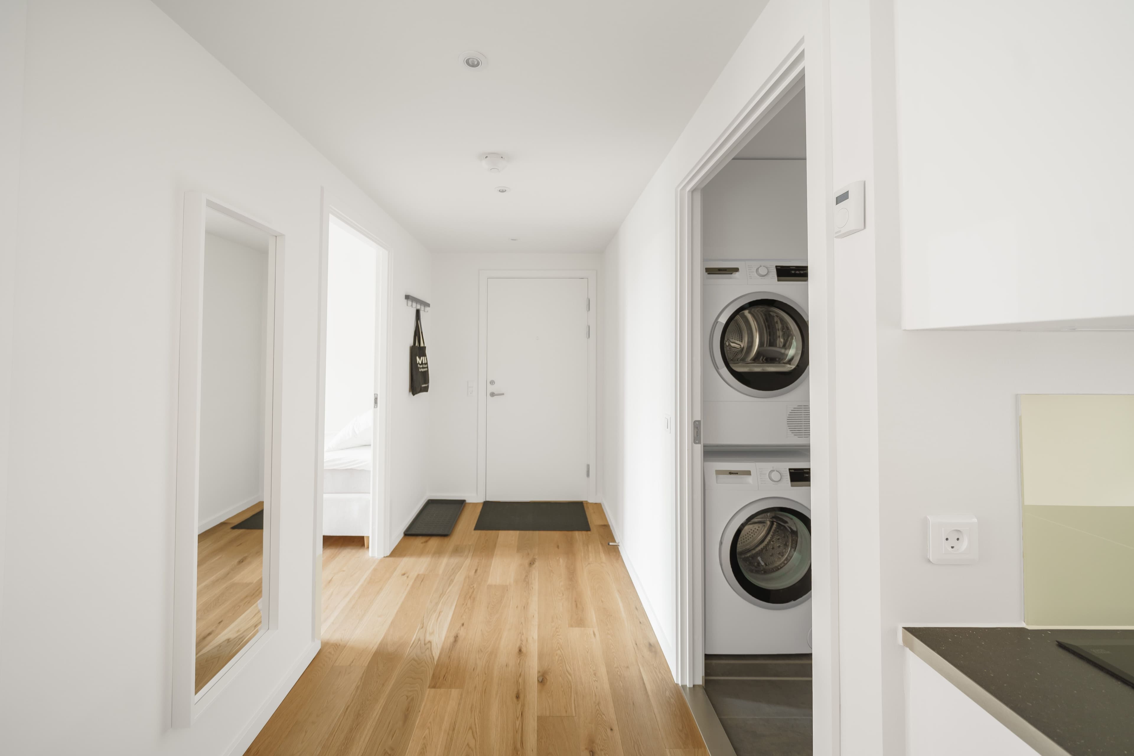 A hallway with a view of a bathroom and bedroom