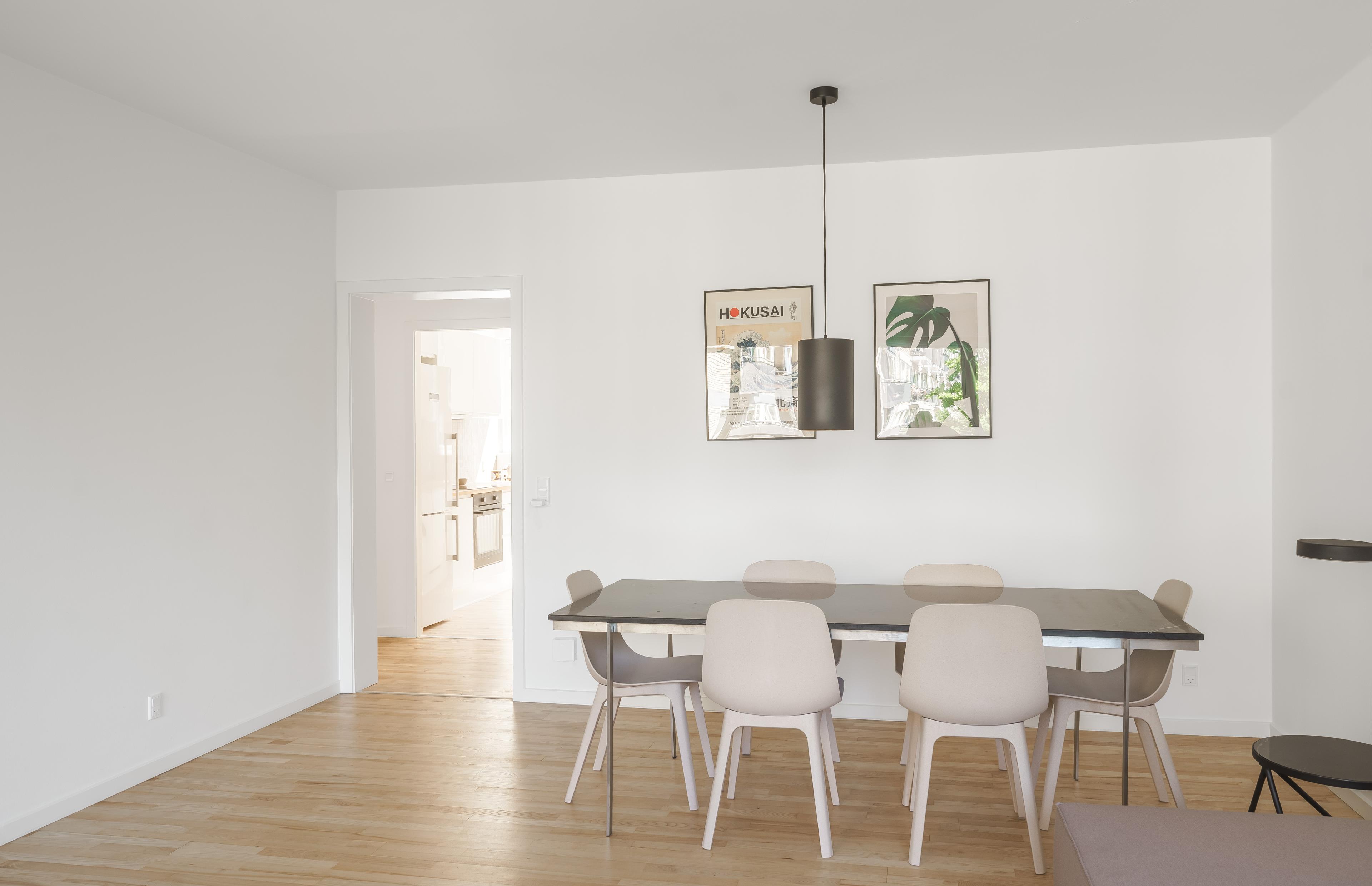 A diningroom with a dining table and a kitchen in the background
